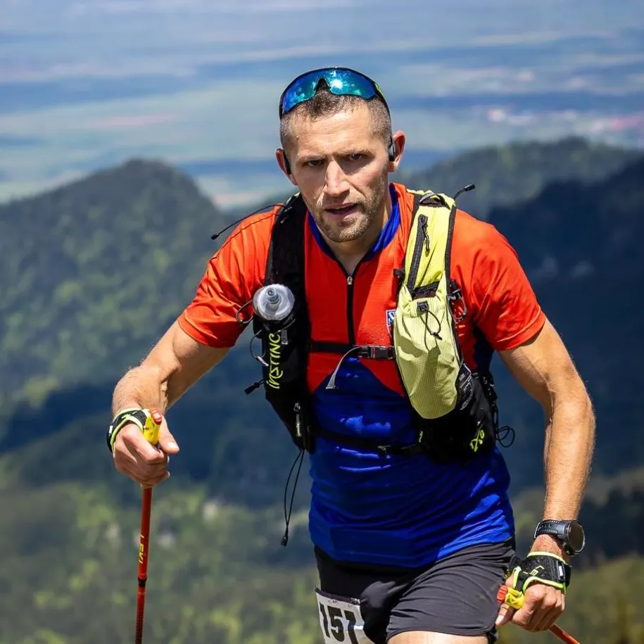 Cornel Buliga alergând pe creastă cu bețe de trail